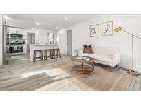 Bright living room with modern decor, including a sofa, round tables, and stylish artwork at 3311 Jasmine St, Denver, CO 80207