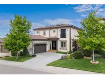 Stunning two-story home featuring a lush front yard, a two-car garage and elegant architectural details at 10468 Ladera Dr, Lone Tree, CO 80124