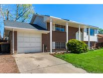 Charming two-story brick home with a covered porch, attached garage, and a well-manicured lawn at 1081 E 119Th Pl, Northglenn, CO 80233