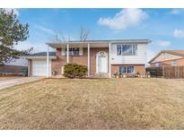 Charming brick home featuring a covered porch, attached garage, and well-maintained front yard at 1081 E 119Th Pl, Northglenn, CO 80233
