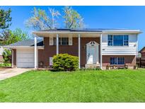 Charming two-story home with a brick facade, manicured lawn, and inviting front porch at 1081 E 119Th Pl, Northglenn, CO 80233