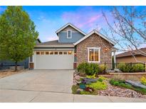 Charming two-story home featuring stone accents, a two-car garage, and a well-maintained front yard with landscaping at 12575 Sandstone Dr, Broomfield, CO 80021