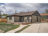 Charming single-story home featuring a welcoming front porch, landscaped yard, and private driveway at 6000 Yarrow St, Arvada, CO 80004