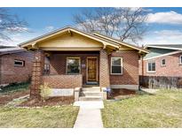 Charming brick bungalow with covered front porch, walkway, and freshly landscaped front yard at 2039 S Sherman St, Denver, CO 80210