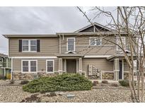 Attractive townhouse featuring tan siding, stone accents, and tidy landscaping on an overcast day at 9023 Apache Plume Dr # D, Parker, CO 80134