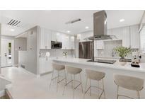 Bright, modern kitchen with white cabinets, stainless steel appliances, and a spacious island at 12992 W Jewell Cir, Lakewood, CO 80228