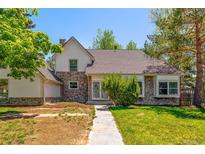 Charming two-story home boasts stone accents, a well-maintained lawn, and mature trees at 4850 S Kittredge St, Aurora, CO 80015