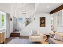 Bright and airy living room featuring a soaring ceiling, wood floors, and modern decor at 4850 S Kittredge St, Aurora, CO 80015