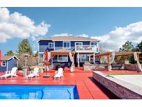 Stunning backyard featuring a pool, hot tub, and outdoor kitchen area with a large deck for entertaining at 5202 Fairfield Cir, Castle Rock, CO 80104