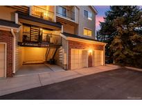 View of a two-car garage, external staircase, and condo unit with parking space at 13744 E Lehigh Ave # B, Aurora, CO 80014