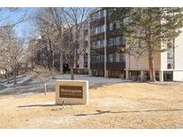 View of the building exterior featuring the community sign, landscaping, and architectural details at 3470 S Poplar St # 401, Denver, CO 80224