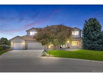 Charming brick home with well-manicured lawn, mature trees, and three-car garage at 7226 Dove Ct, Parker, CO 80134