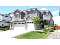 Charming two-story home featuring a three-car garage, red shutters, stone accents and a well-manicured front yard at 14763 Pepper Pike Pl, Parker, CO 80134