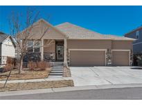 Charming home with a three-car garage, complemented by stone accents and a well-manicured lawn at 6434 N Ensenada Ct, Aurora, CO 80019