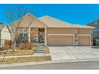 Charming single-Gathering home with a three-car garage and stone veneer accents on a sunny day at 6434 N Ensenada Ct, Aurora, CO 80019