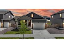 Charming home featuring a manicured lawn, a 2-car garage, and inviting front porch under a beautiful sunset sky at 4642 Longs Peak St, Brighton, CO 80601