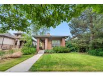 Charming single-story home featuring a well-manicured lawn and inviting, covered front porch at 1076 Rosemary St, Denver, CO 80230