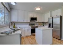 Bright kitchen with white cabinetry, stainless steel appliances, and a convenient center island at 13382 Franklin St, Thornton, CO 80241
