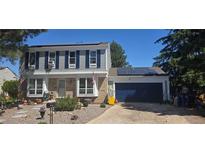 Charming two-story home with blue shutters, solar panels, brick accents and manicured front yard at 1024 S Mobile St, Aurora, CO 80017