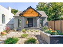 Charming gray brick home with a well-manicured front yard and stone pathway at 604 Inca St, Denver, CO 80204