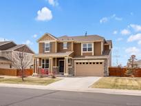 Inviting two-story home featuring a covered porch, two-car garage, and a well-maintained front yard at 353 Zuniga St, Brighton, CO 80601