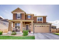 Charming two-story home featuring stone accents, a covered porch, and a two-car garage at 353 Zuniga St, Brighton, CO 80601