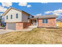 Charming two-story home with brick accents, gray siding, and an attached two car garage at 3915 E Jamison Pl, Centennial, CO 80122
