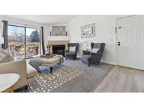 Bright living room features a fireplace, balcony access, and modern decor for a cozy, stylish space at 10263 E Peakview Ave # C202, Englewood, CO 80111