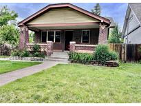 Charming brick home featuring a well-maintained lawn and classic architectural details at 2835 Cherry St, Denver, CO 80207