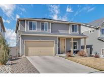 Two-story gray home with a beige two car garage and an easy to maintain lawn on a bright sunny day at 5251 Truckee St, Denver, CO 80249