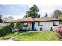 Charming single-story home with blue front door, wooden and painted brick details, and mature landscaping at 11354 Allendale Dr, Arvada, CO 80004
