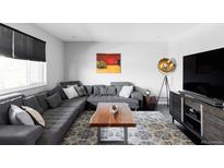Inviting living room featuring a plush sectional sofa, stylish rug, and contemporary decor at 11354 Allendale Dr, Arvada, CO 80004