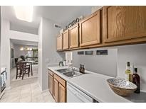 Well-lit kitchen features wooden cabinetry, stainless steel sink, and white countertop at 7481 Singing Hills Dr, Boulder, CO 80301