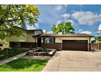 Charming two-story home with a brick facade, manicured lawn, mature trees, and an attached two-car garage at 280 Jupiter Dr, Lone Tree, CO 80124