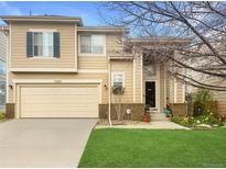 Charming two-story home with a well-maintained lawn, a two-car garage, and mature landscaping at 9469 W Ute Dr, Littleton, CO 80128