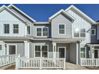 Modern two-story townhome with gray siding, white trim, and a front porch at 14556 W 91St Ave # C, Arvada, CO 80005