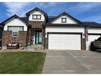 Charming two-story home featuring a stone facade, white siding, and a two-car garage at 11699 Pink Phlox Dr, Parker, CO 80134