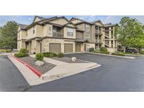 Attractive condo building showcasing attached garages, stone accents, balconies, and well-maintained landscaping at 7418 S Quail Cir # 1312, Littleton, CO 80127