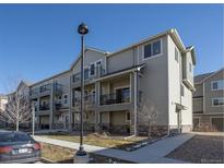 Modern condo building with multiple balconies and attractive landscaping under a blue sky at 11250 Florence St # 28F, Commerce City, CO 80640