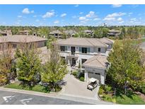 Elegant two-story home with a tile roof, lush landscaping, and a golf cart parked on the driveway at 9171 E Harvard Ave, Denver, CO 80231