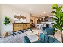 Inviting living room featuring stylish furnishings, a modern cabinet, and an open layout with an adjacent kitchen at 6153 N Ceylon St # 303, Denver, CO 80249