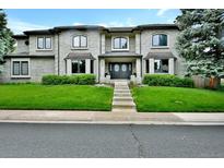 Stunning two-story home with manicured lawn, brick facade, bay windows, and arched entryway at 5329 S Geneva St, Englewood, CO 80111