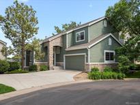 Charming two-story home with stone accents, attached garage, and a well-manicured front yard at 7400 W Grant Ranch Blvd # 19, Littleton, CO 80123