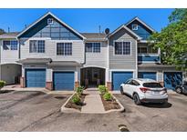 Attractive townhome featuring attached garages and appealing blue and gray color scheme on a sunny day at 19172 E Arkansas Dr # 106, Aurora, CO 80017
