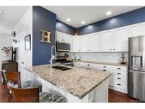 Bright kitchen featuring granite countertops, stainless steel appliances, and white cabinetry at 4401 Hydrangea Way, Castle Rock, CO 80109