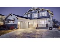 Charming two-story home showcasing a well-manicured lawn, covered porch, and attached two-car garage at 785 Delechant Dr, Erie, CO 80516