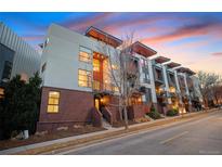 Modern townhome showcases contemporary design, brick facade, with private balcony under a beautiful sunset sky at 1878 W 32Nd Ave, Denver, CO 80211