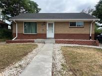 Charming brick home with well-maintained front yard, concrete walkway and steps, and white trim at 1283 Lipan Dr, Denver, CO 80221