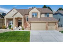 Charming two-story home with a three-car garage, brick accents, and a well-maintained front lawn at 534 Stonemont Dr, Castle Pines, CO 80108