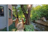 Charming exterior view featuring a quaint wooden bridge over a tranquil stream at 1633 18Th St St # 2, Boulder, CO 80302